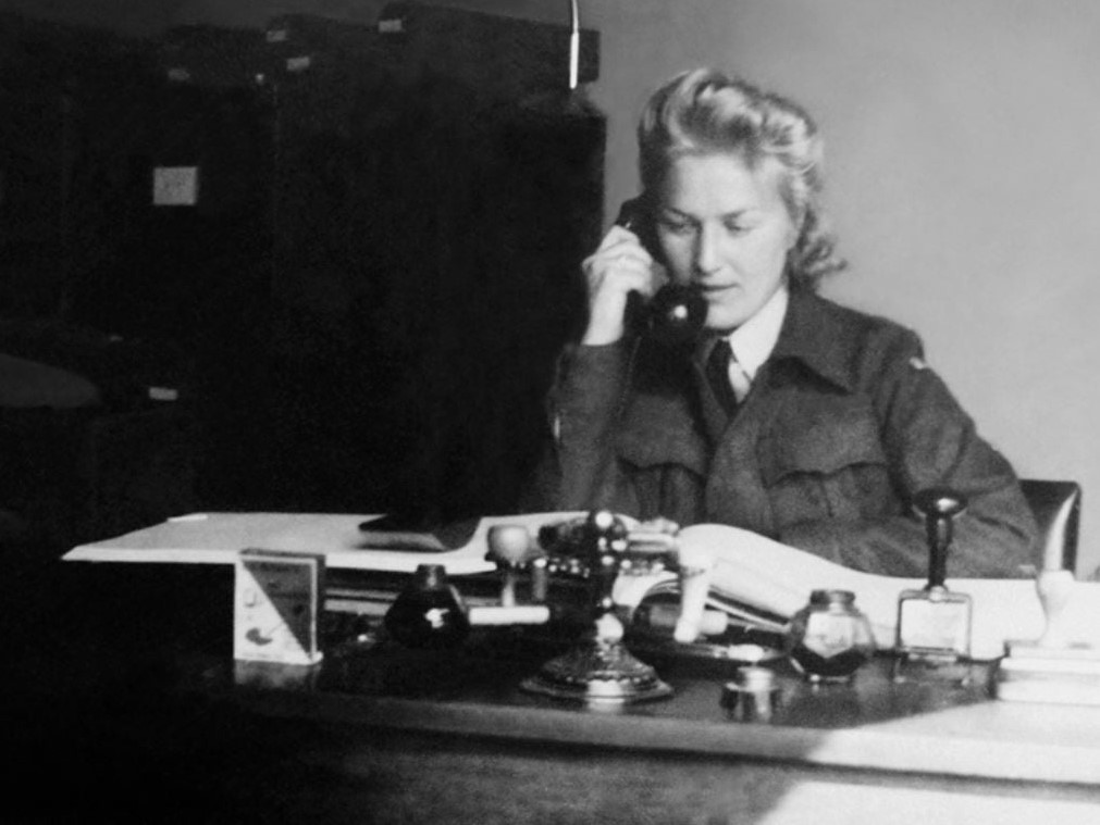 Damen Liv Grannes som prater i telefonen ved en kontorpult
