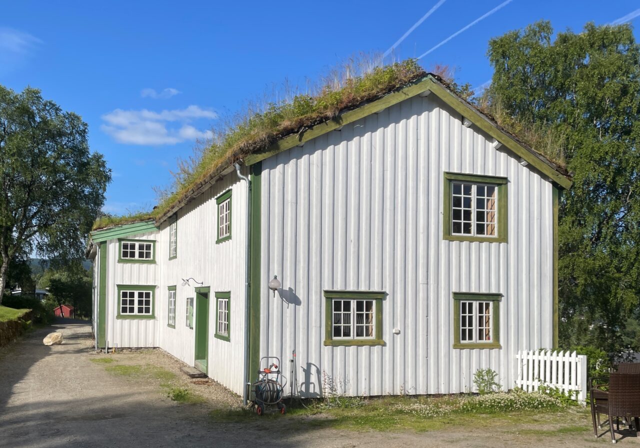 Stenneset museum. Hvitt gammelt bygg med torvtak. Foto