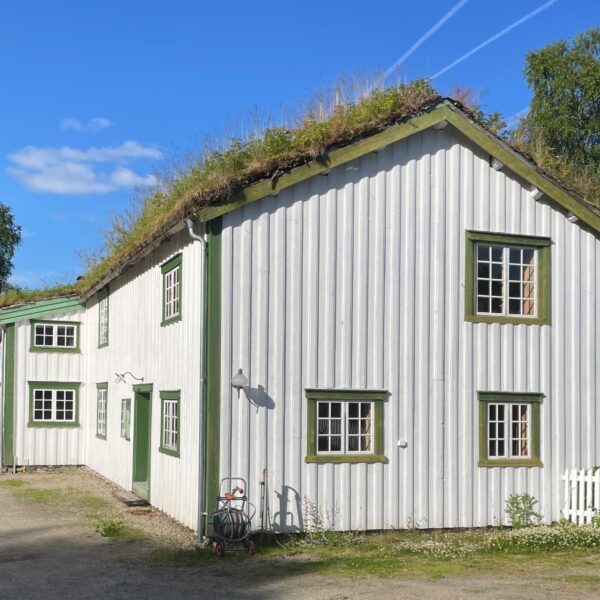 Stenneset museum. Hvitt gammelt bygg med torvtak. Foto